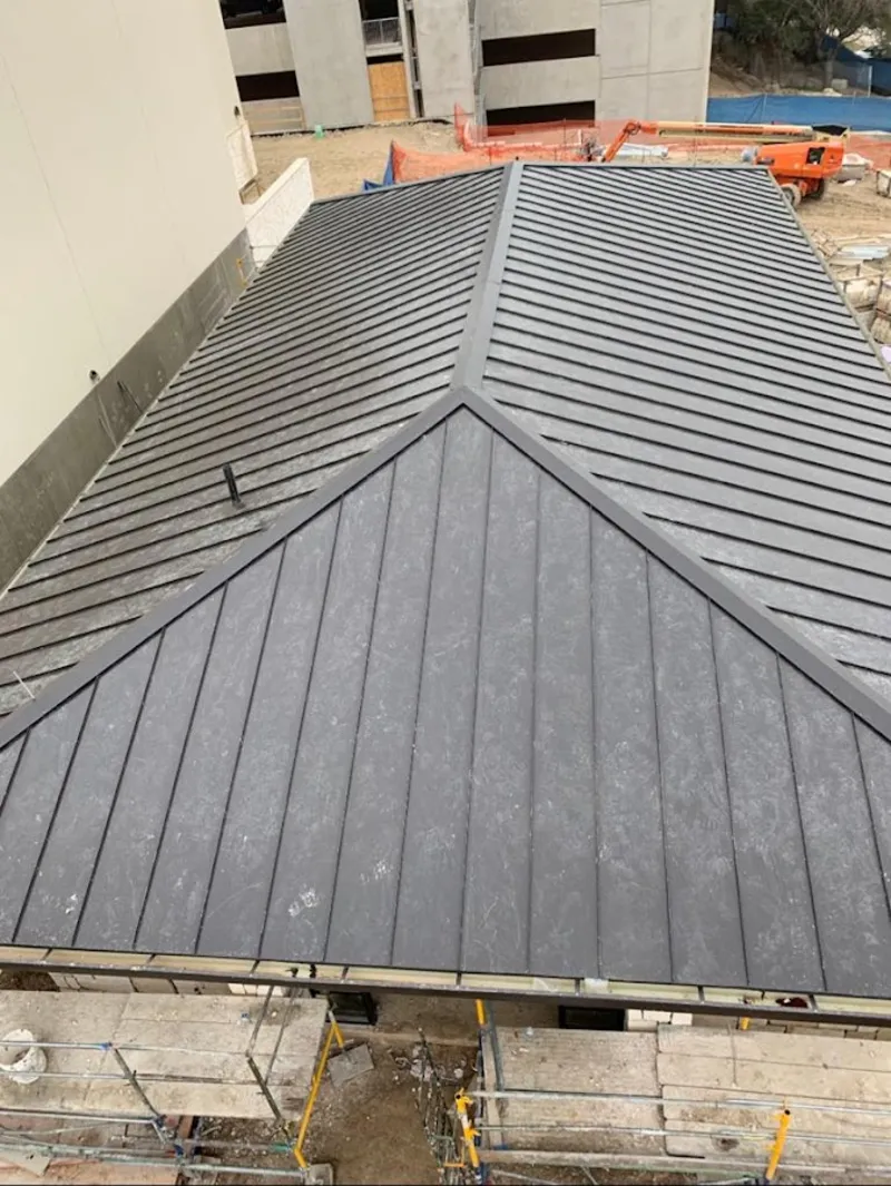 Commercial metal roof construction with crane equipment in Vadnais Heights